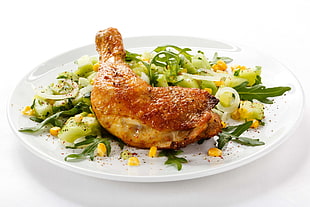 roasted chicken leg with vegetables on white ceramic plate